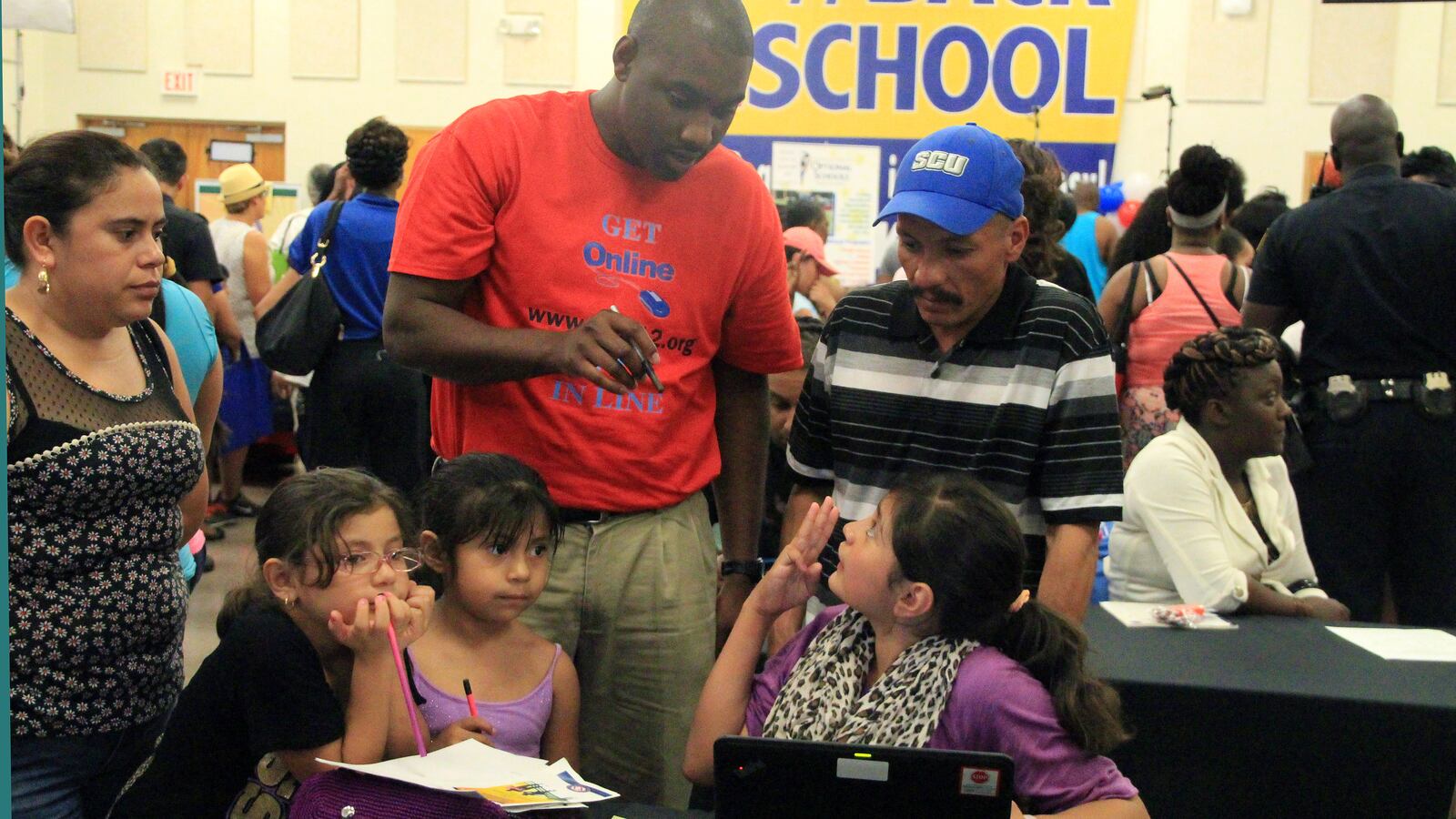 Roxanna Vasquez, 11, speaks with district employee Brandon Pinson at the online student registration kickoff for Shelby County Schools.