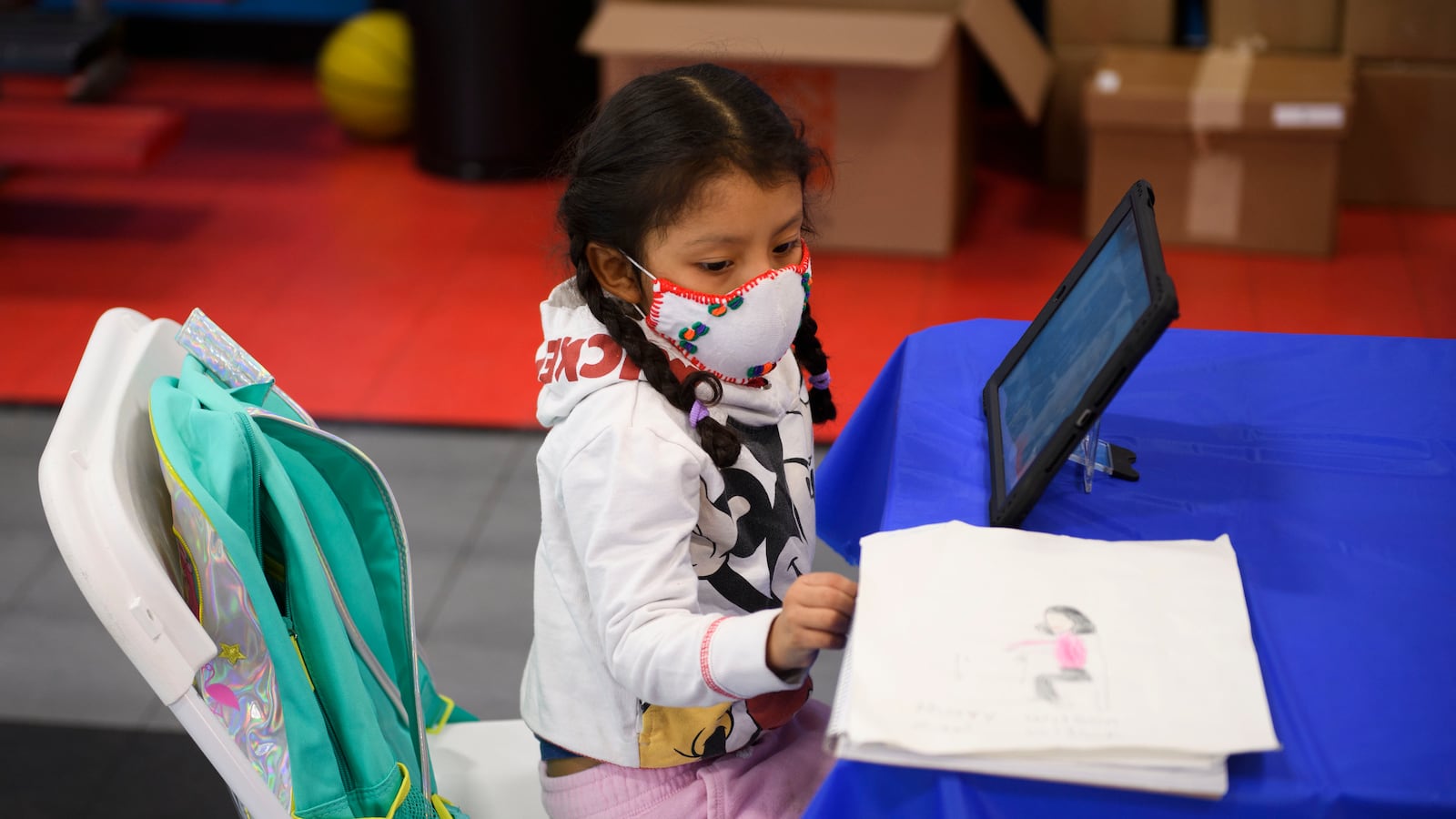 A young girl works at a tablet in a gymnasium on an online tutoring platform.
