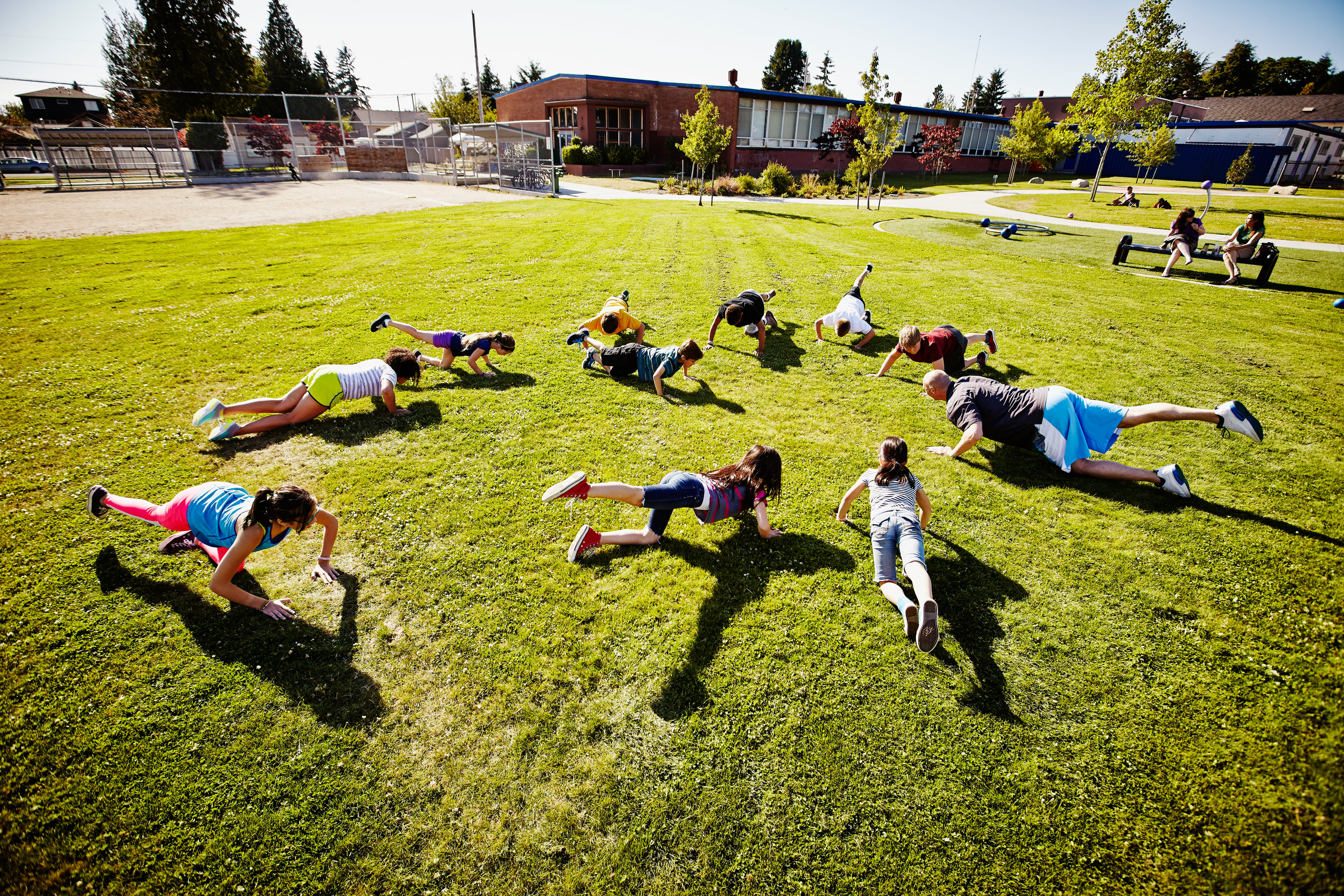 Students are arranged in a circle outside a school building.