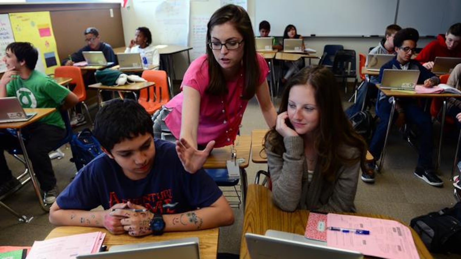 Algebra teacher Jessica Edwards helps students Yosef Abuharus, 14, left, and Emily Botkin, 14, right, with math problems during her 9th grade algebra class  at Smoky Hill High School last  year (Photo by Helen H. Richardson/ The Denver Post).