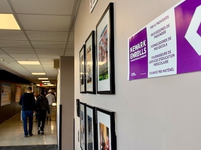 A high school hallway with posters on the wall and people walking in the background.