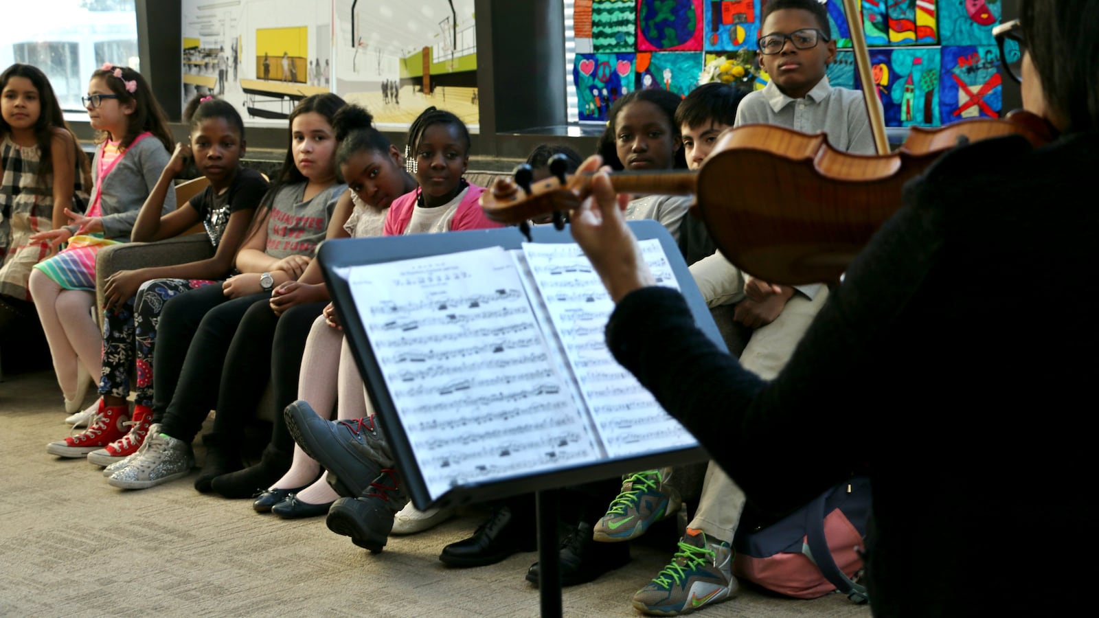 Students listened to their music teacher play violin at a P.S. 191 community event at Lincoln Center this spring. Fernando Taylor, a seventh-grade student who is the son of PTA President Charles Taylor, is seated far right. (Photo: Patrick Wall)