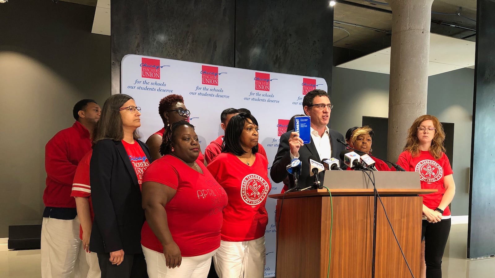 Jesse Sharkey holds up a copy of the expired union contract at a press conference on July 1, 2019.