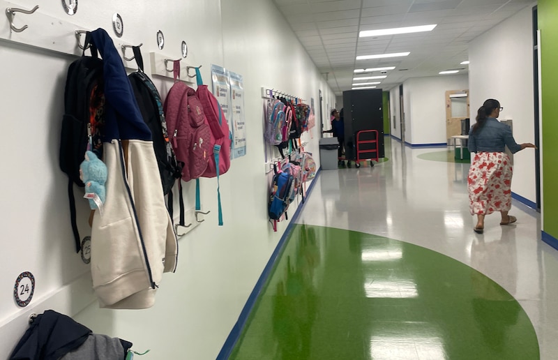 Book bags line a hallway.