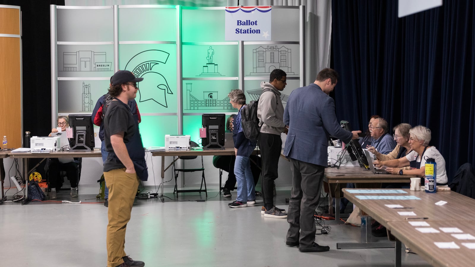 People stand around tables in a large room.