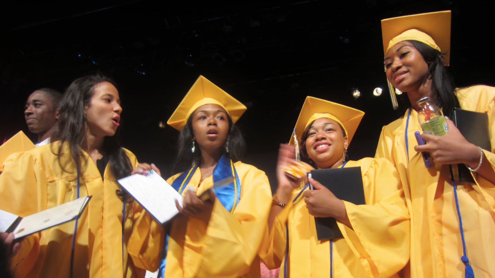 Democracy Prep graduates holding diplomas and Snapple.