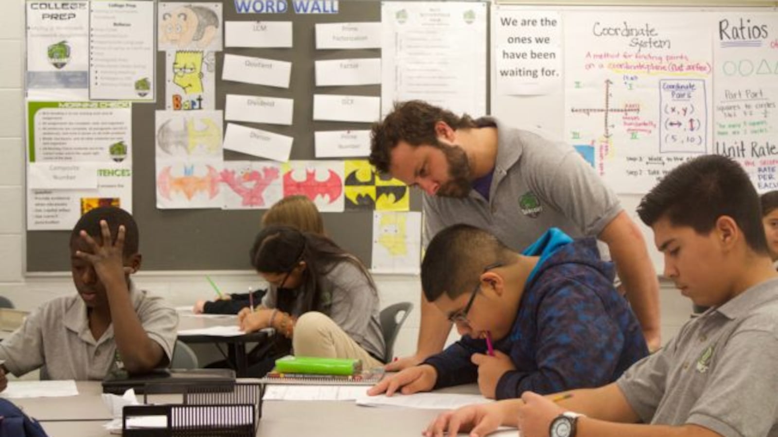 A DSST Cole Middle School teacher checks on students work during a class in November 2015.