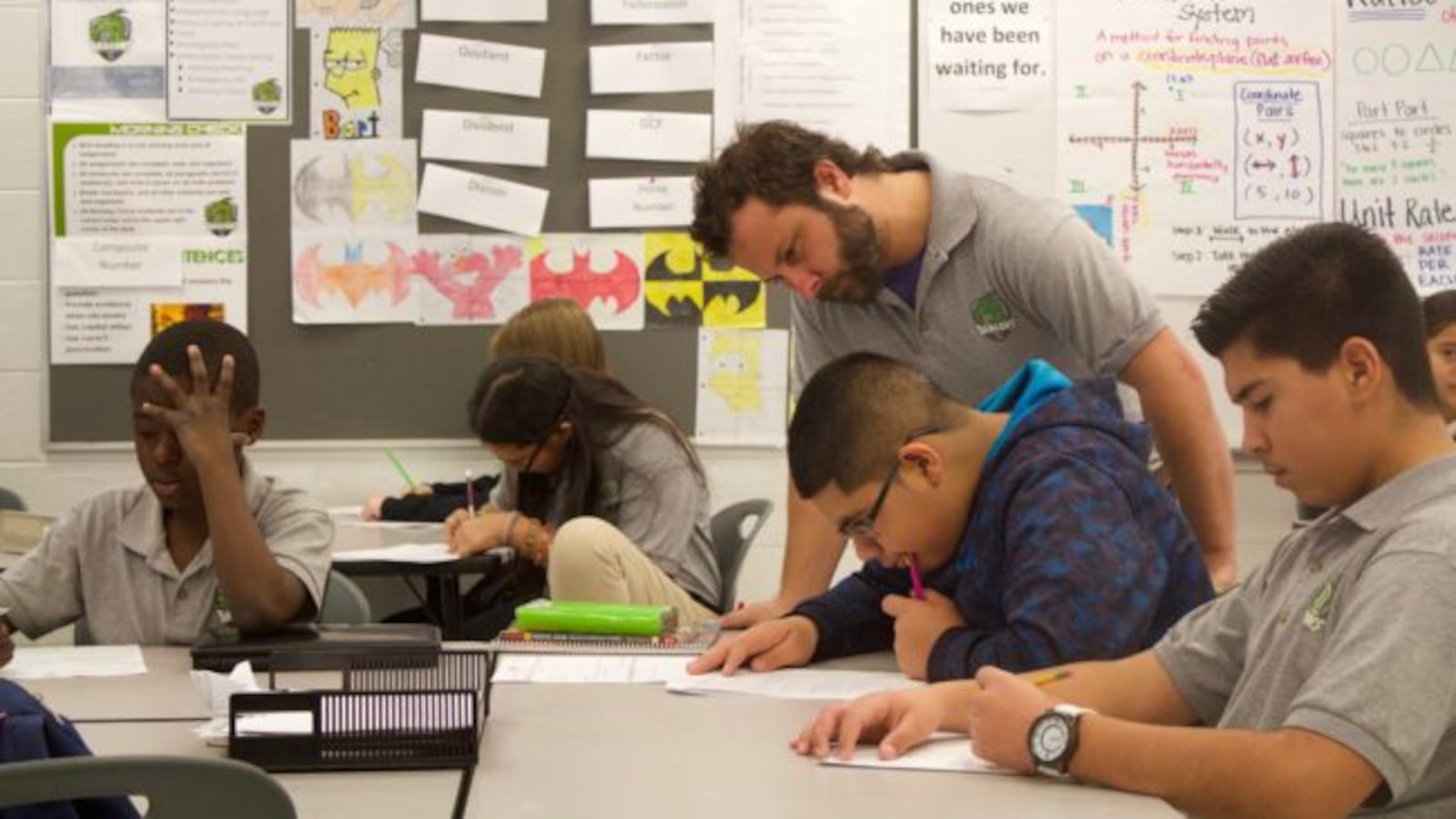 A DSST Cole Middle School teacher checks on students work during a class in November 2015.