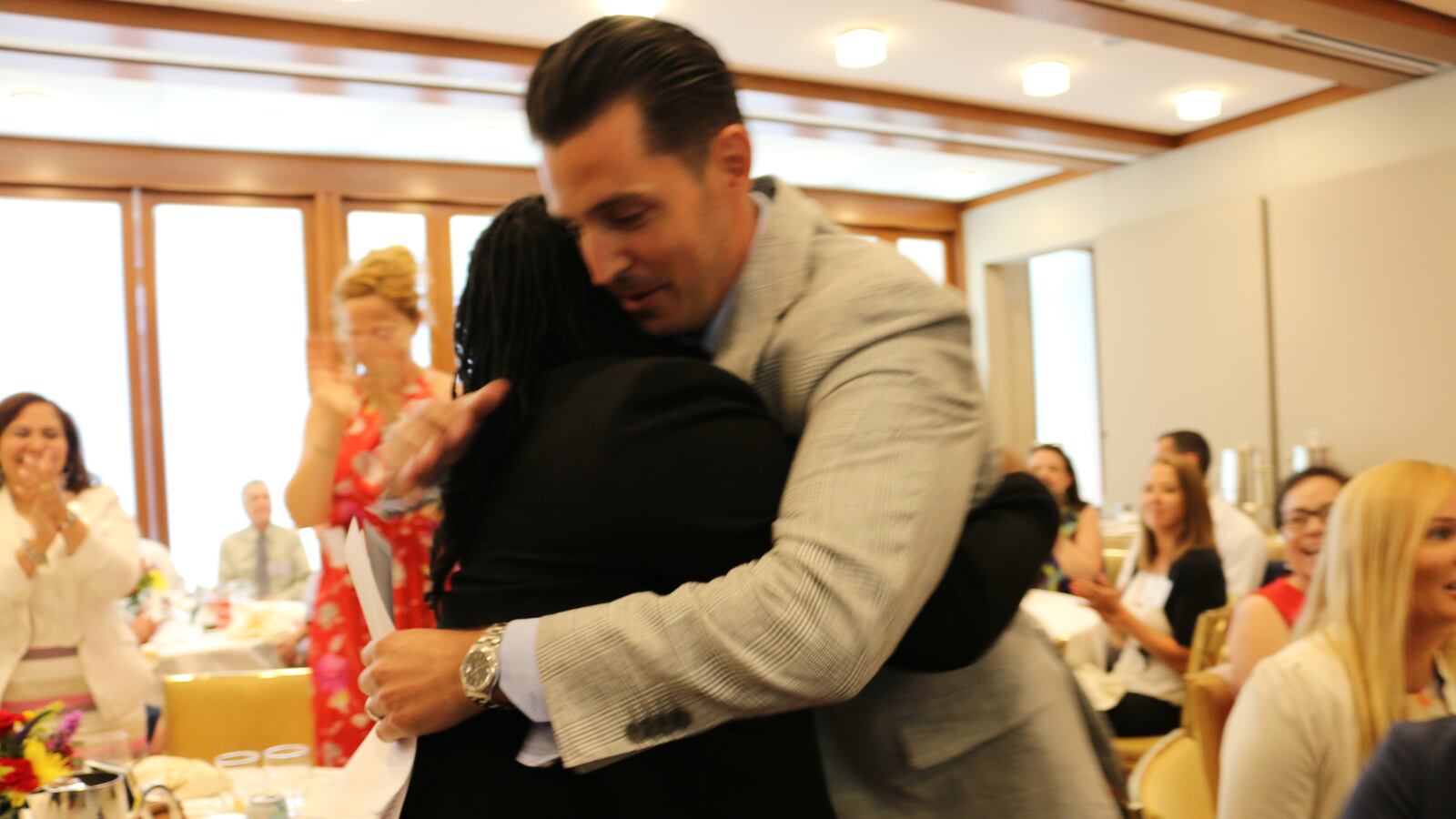 Vincent Gassetto, the principal M.S. 343, hugs a staff member after winning the Teaching Matters prize in July 2017.