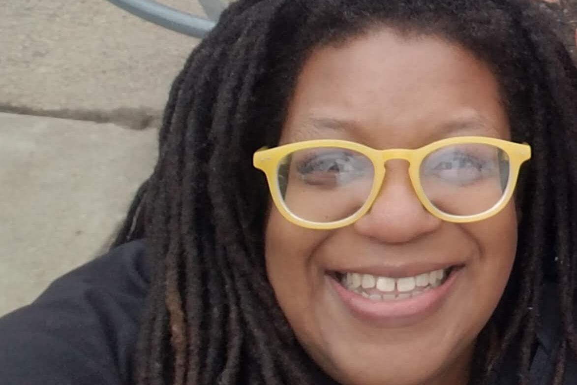 A woman in yellow glasses smiling