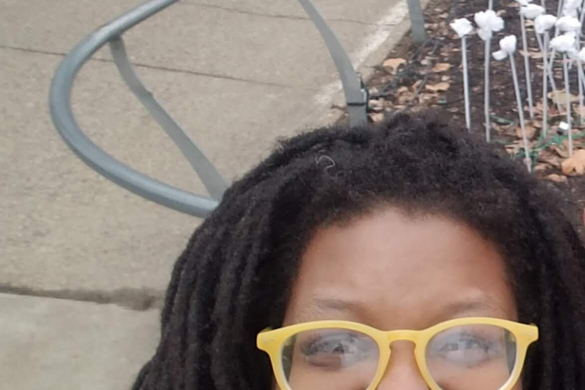 A woman in yellow glasses smiling