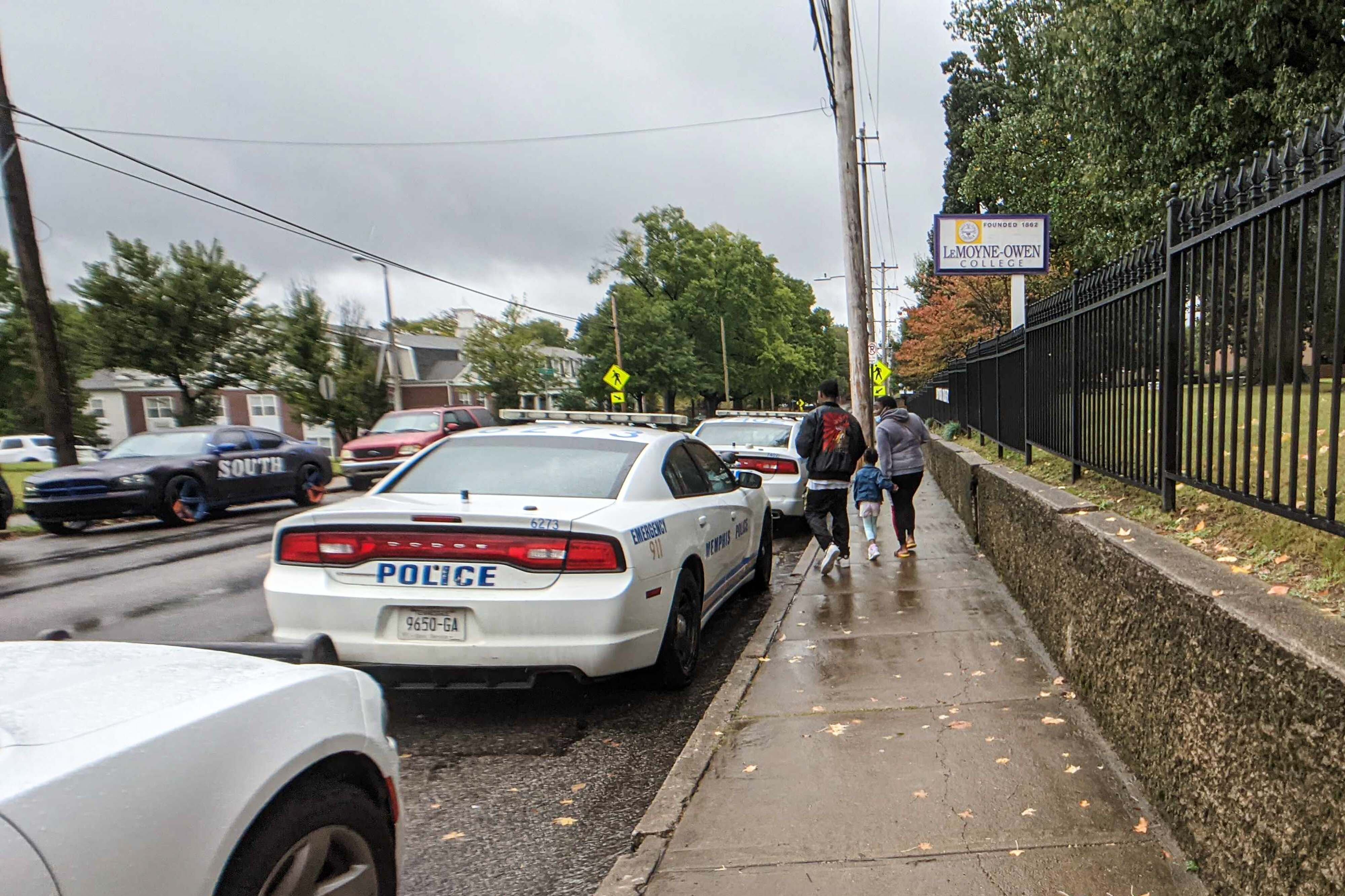 Parents walk past police vehicles following a shooting at Cummings Elementary School in Memphis.