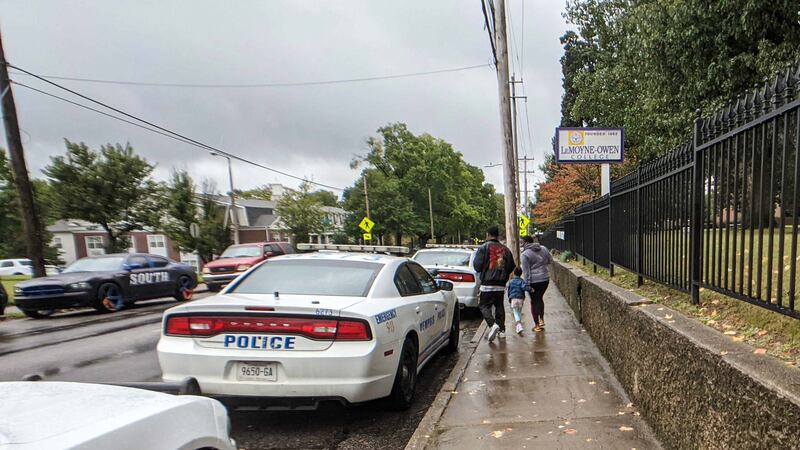 Parents walk past police vehicles following a shooting at Cummings Elementary School in Memphis.