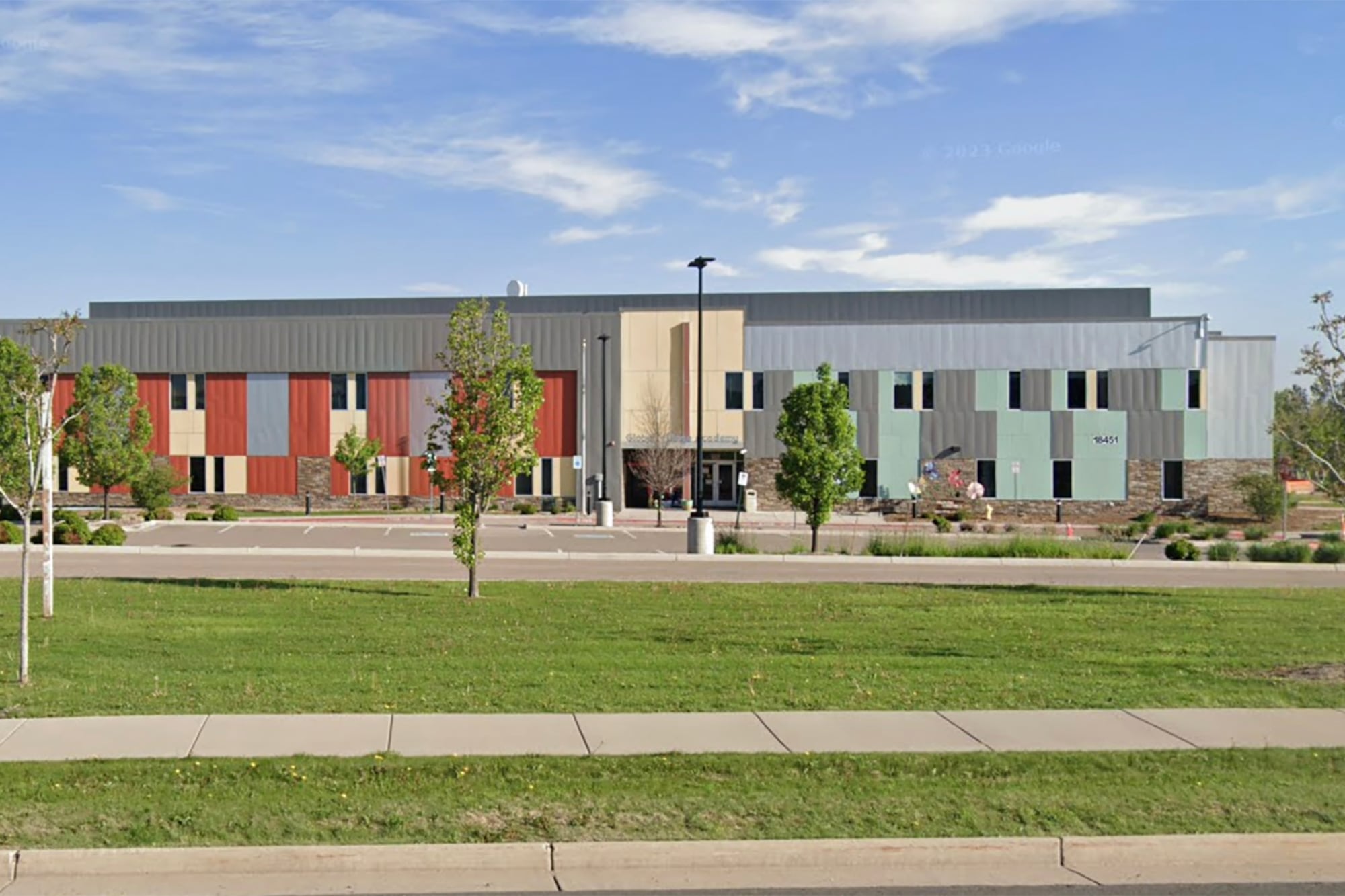 A screen grab of a google maps street view of a school building on a sunny day with green grass in the foreground.