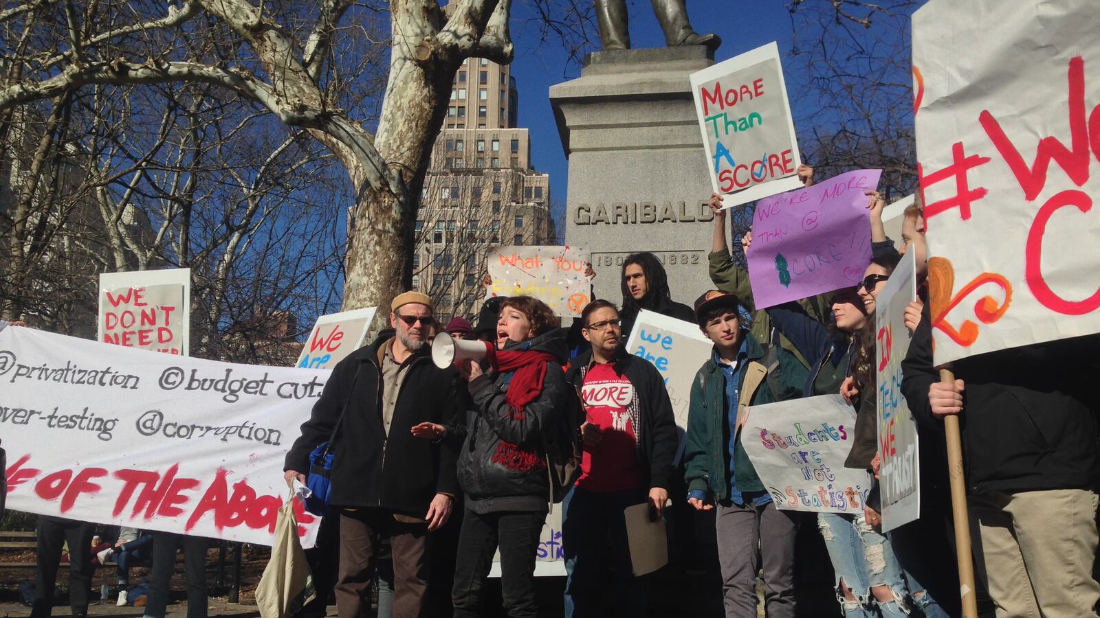 Sarah Quinter, an artist and educator who graduated from City-As-School in 2004, speaks to demonstrators gathered at Washington Square Park to protest Gov. Cuomo’s proposed education policy changes.