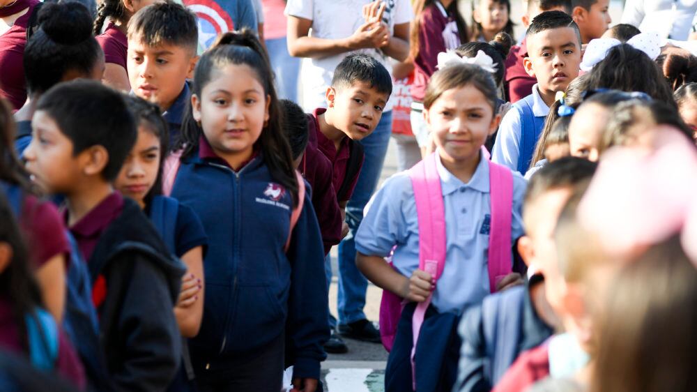 Angel Trigueros-Martinez pokes his head from the back of the line as students wait to enter the building on the first day of school at McGlone Academy on Wednesday. (Photo by AAron Ontiveroz/The Denver Post)