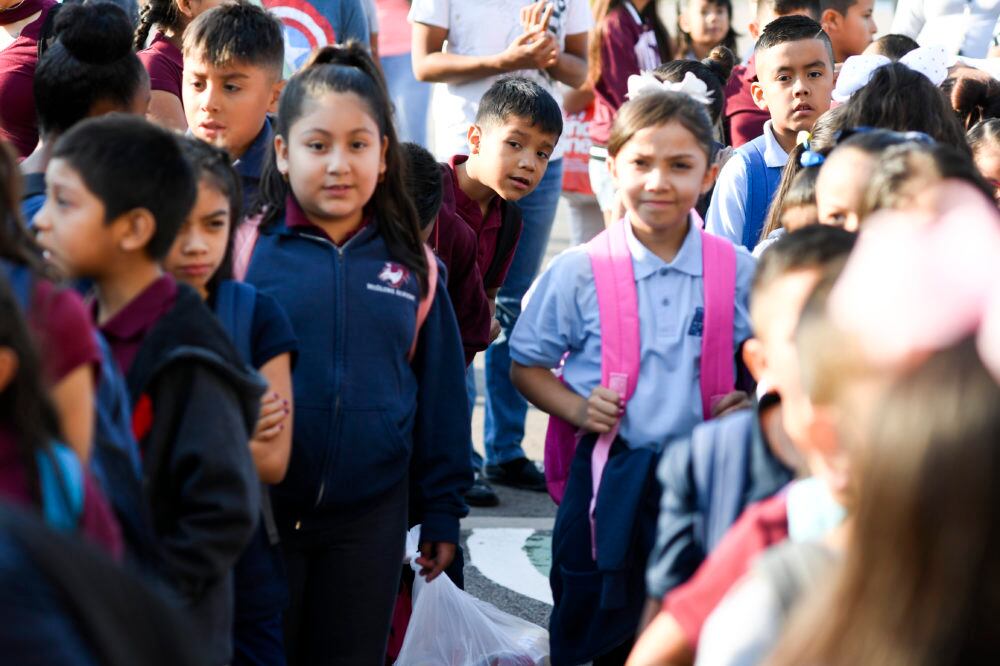 Angel Trigueros-Martinez pokes his head from the back of the line as students wait to enter the building on the first day of school at McGlone Academy on Wednesday. (Photo by AAron Ontiveroz/The Denver Post)