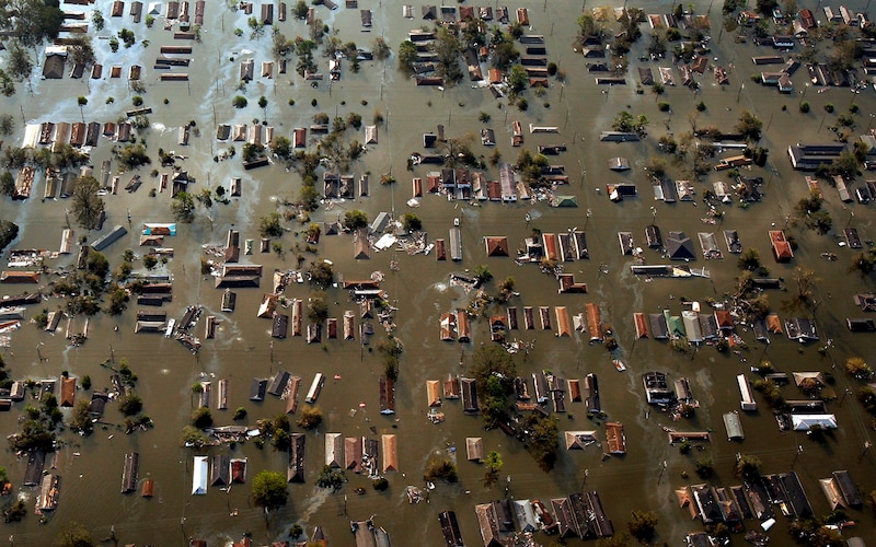 An aerial photograph of the tops of roofs submerged in flood waters.