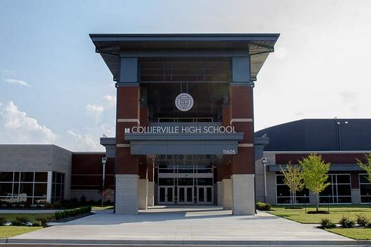 A brown brick school building with a sign reading “Collierville High School.”