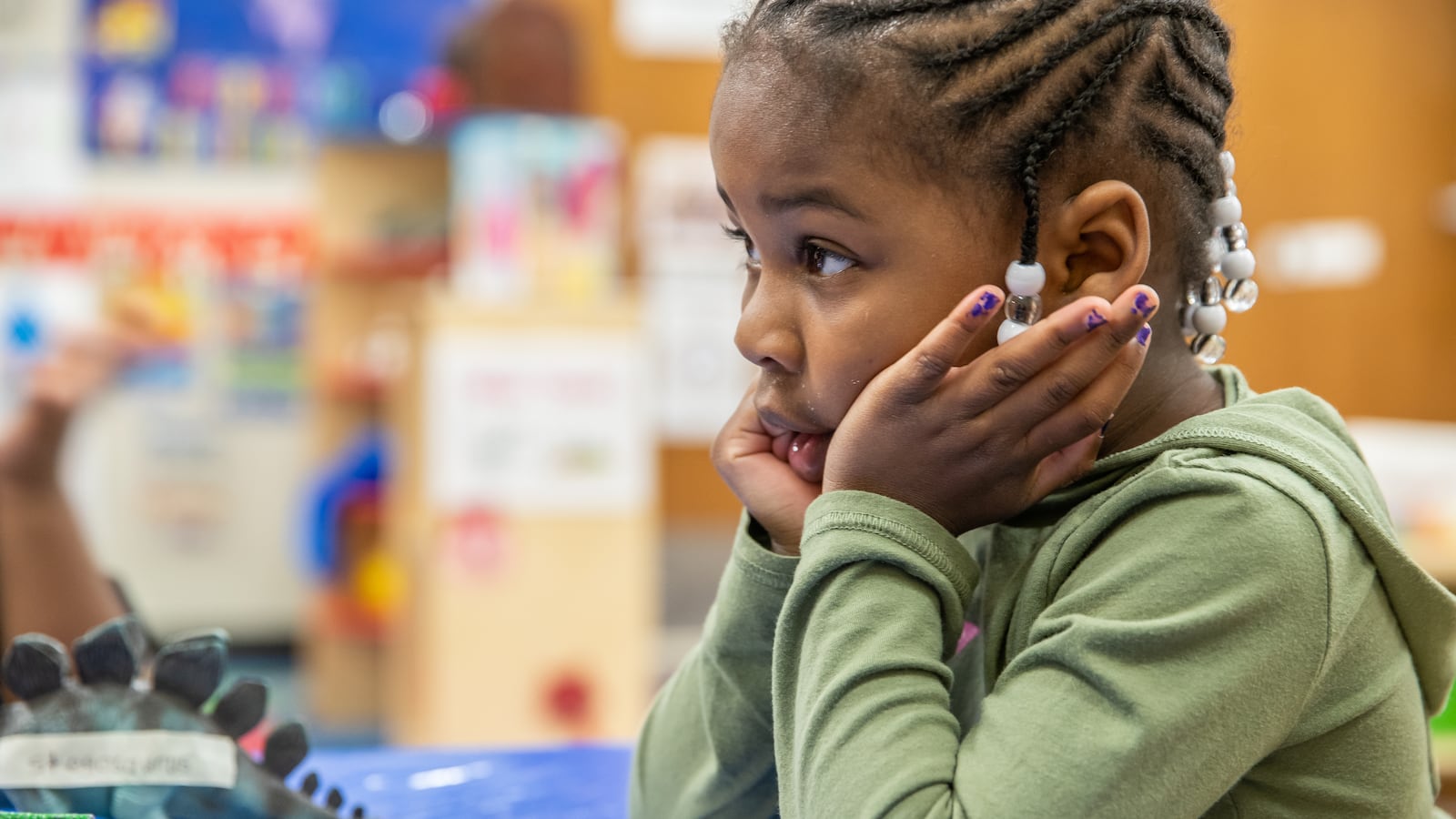 Prius Winters, 4, a pre-kindergarten student at Avondale Meadows YMCA Early Learning Center in Indianapolis, waits for teacher, Cecelia Washington, to label her drawing of her favorite dinosaur during a lesson on Tuesday, April 30, 2019.