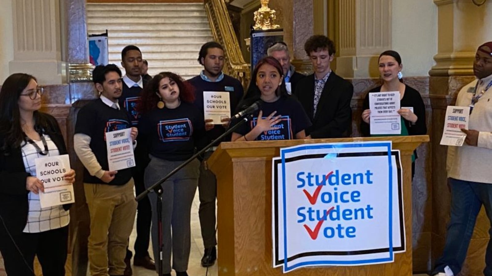 Kayla Morrison, a sophomore at Denver's South High School, speaks in support of 16-year-olds voting in school board elections, surrounded by supporters, including state Rep. Serena Gonzales-Gutierrez (far left) and Denver school board member Tay Anderson (far right).