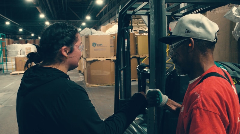 woman and man fist bump in warehouse