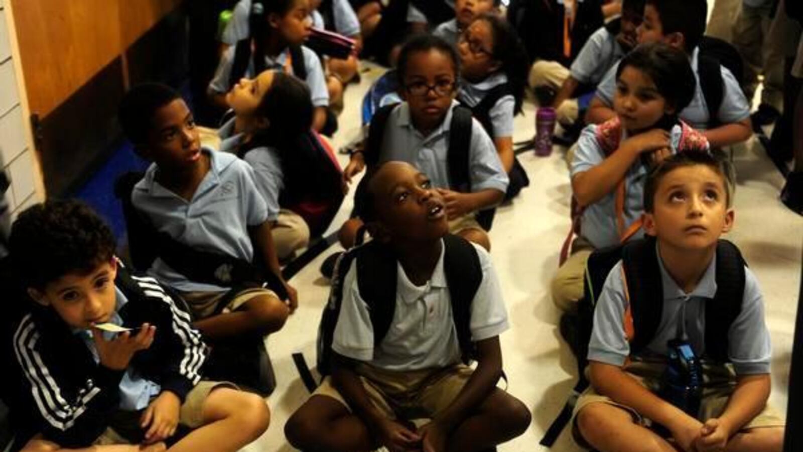 Mauricio Jackson, from left, Raymond Hurley and Adrian Rocha sit in the gym at University Prep charter school before loading on the bus for the ride home.