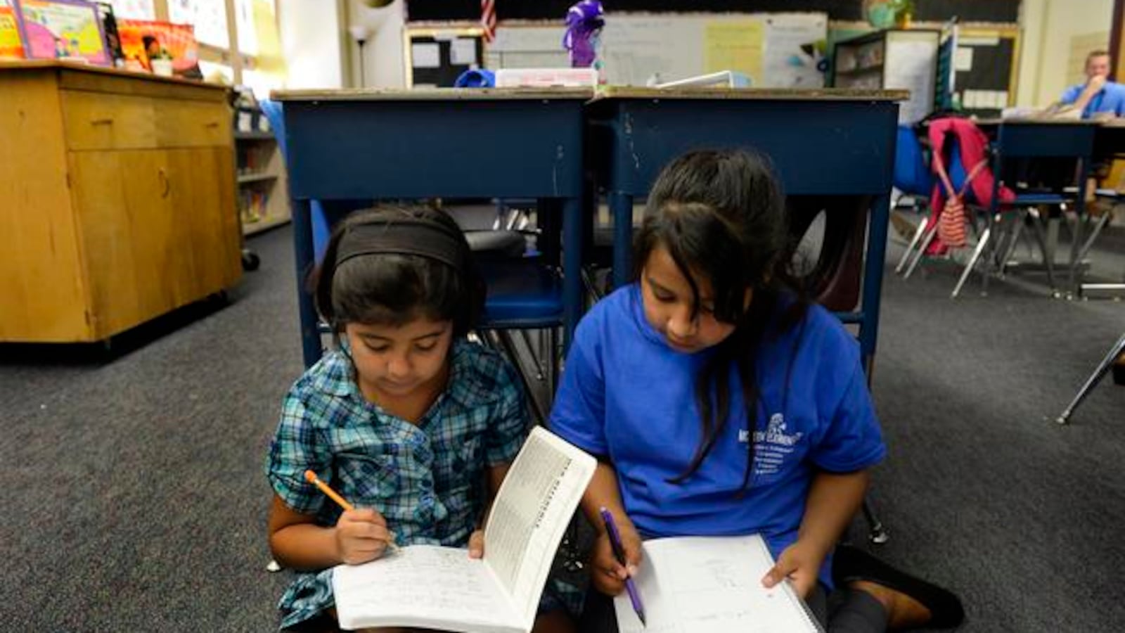 Fifth-graders Abril Magallanes, 10, left, and Julie Vazquez, 10, work together during a math lesson at McMeen Elementary School in 2014.