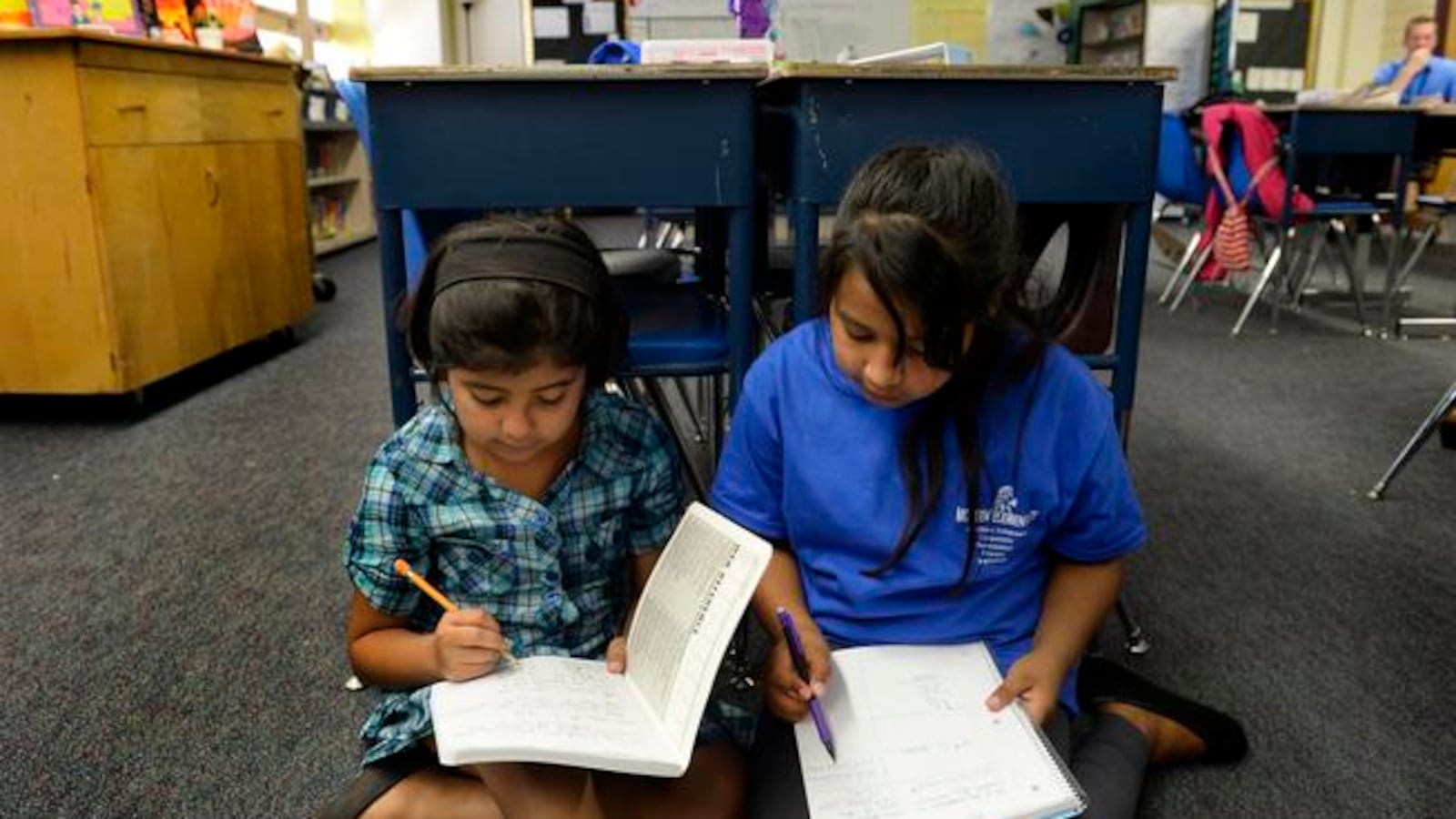 Fifth-graders Abril Magallanes, 10, left, and Julie Vazquez, 10, work together during a math lesson at McMeen Elementary School in 2014.