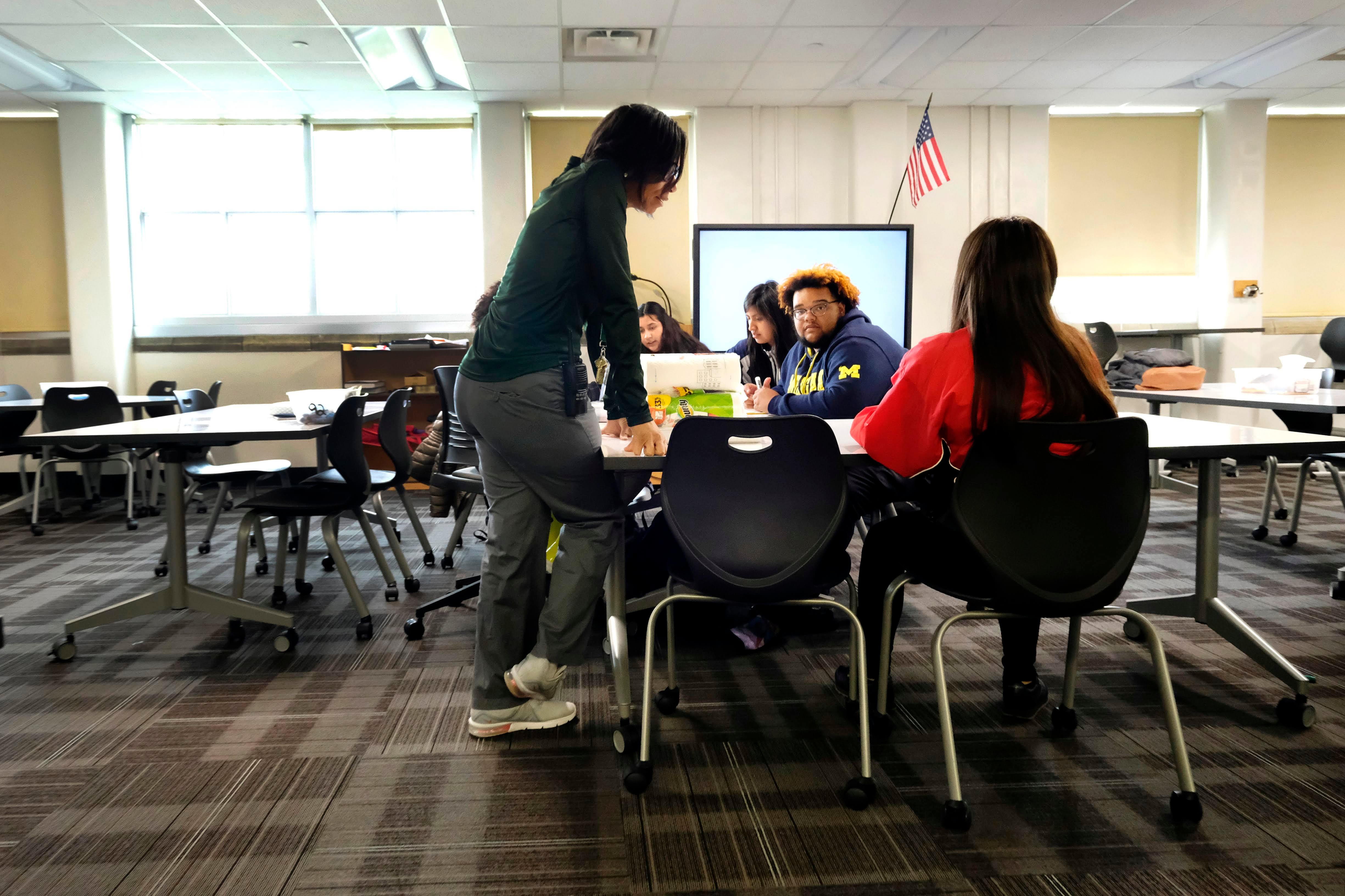 A teacher talks with students inside a classroom at Crispus Attucks High School, a public school in Indianapolis, Indiana in April 2019.