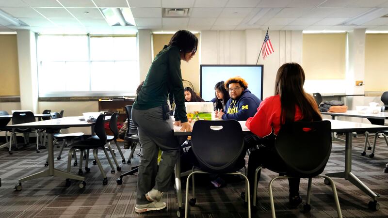 A teacher talks with students inside a classroom at Crispus Attucks High School, a public school in Indianapolis, Indiana in April 2019.