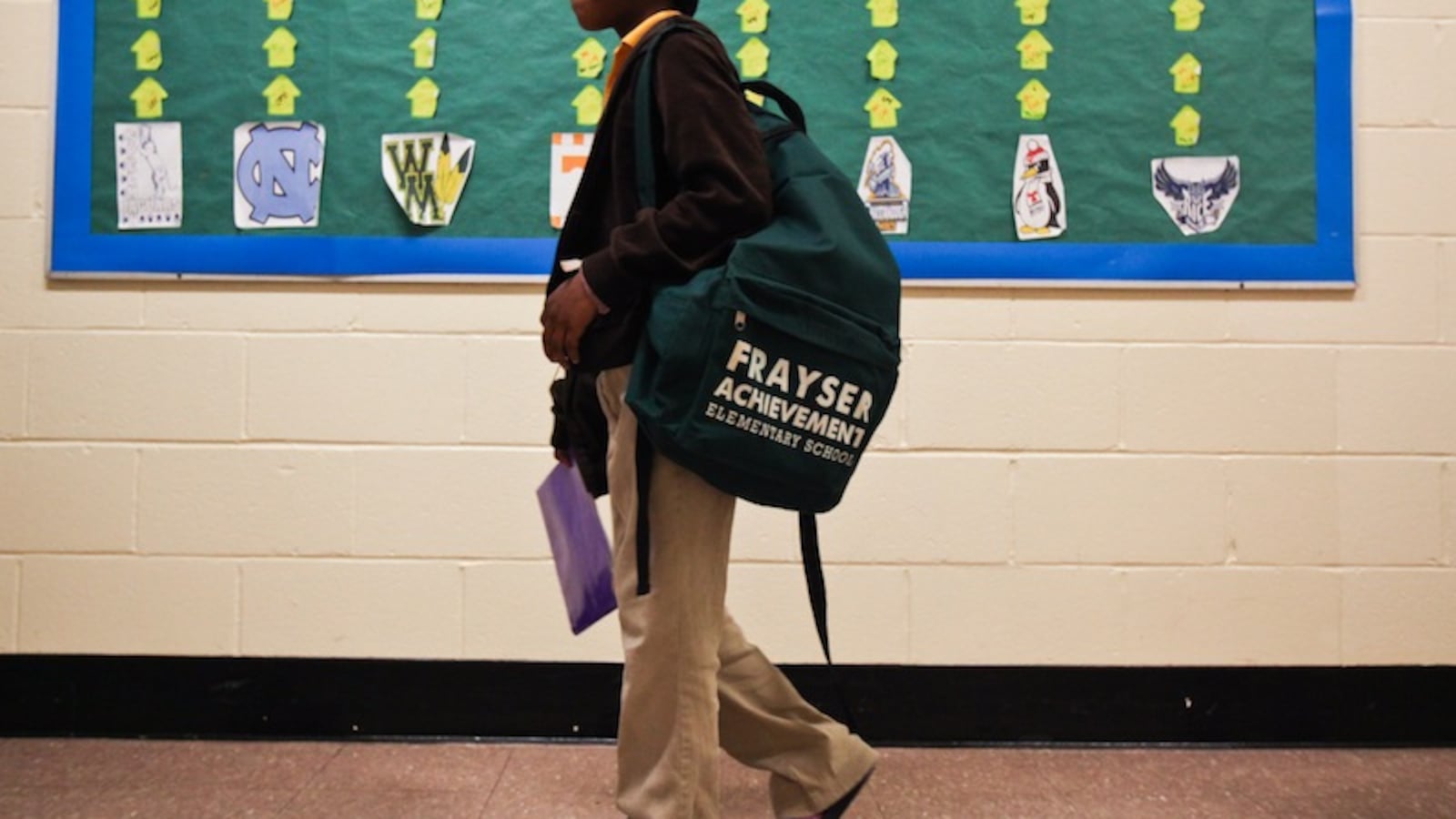 A student at Frayser Achievement Academy walks down the hallway carrying a backpack.