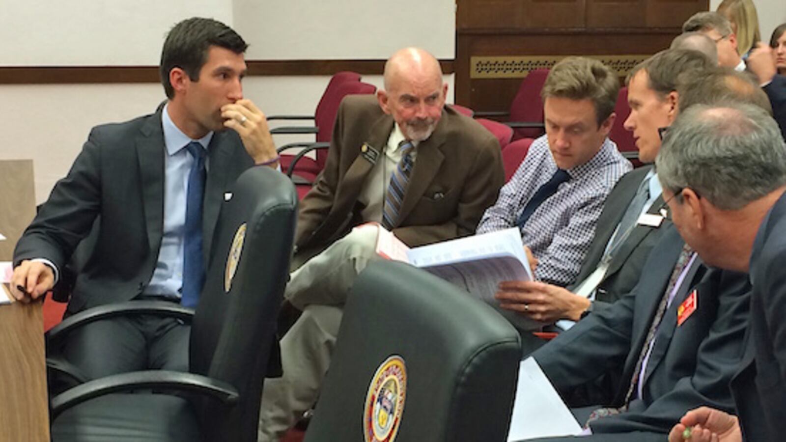 Sens. Owen Hill (left), Mike Merrifield and Mike Johnston consult with legislative staff about the school finance bill.