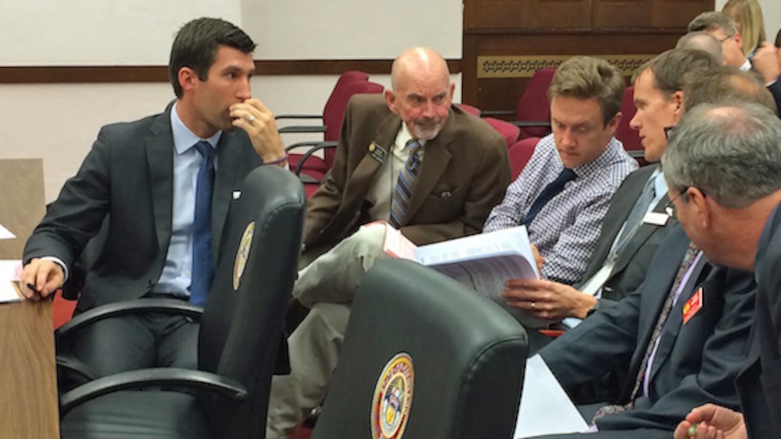 Sens. Owen Hill (left), Mike Merrifield and Mike Johnston consult with legislative staff about the school finance bill.