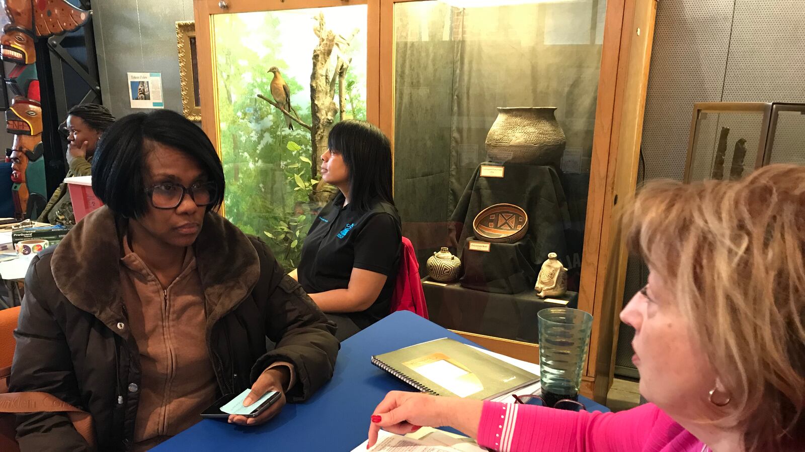 April Thomas enrolls her son with Deborah Louis-Ake, who leads the main district's special education placement at the Children's  Museum in Detroit.