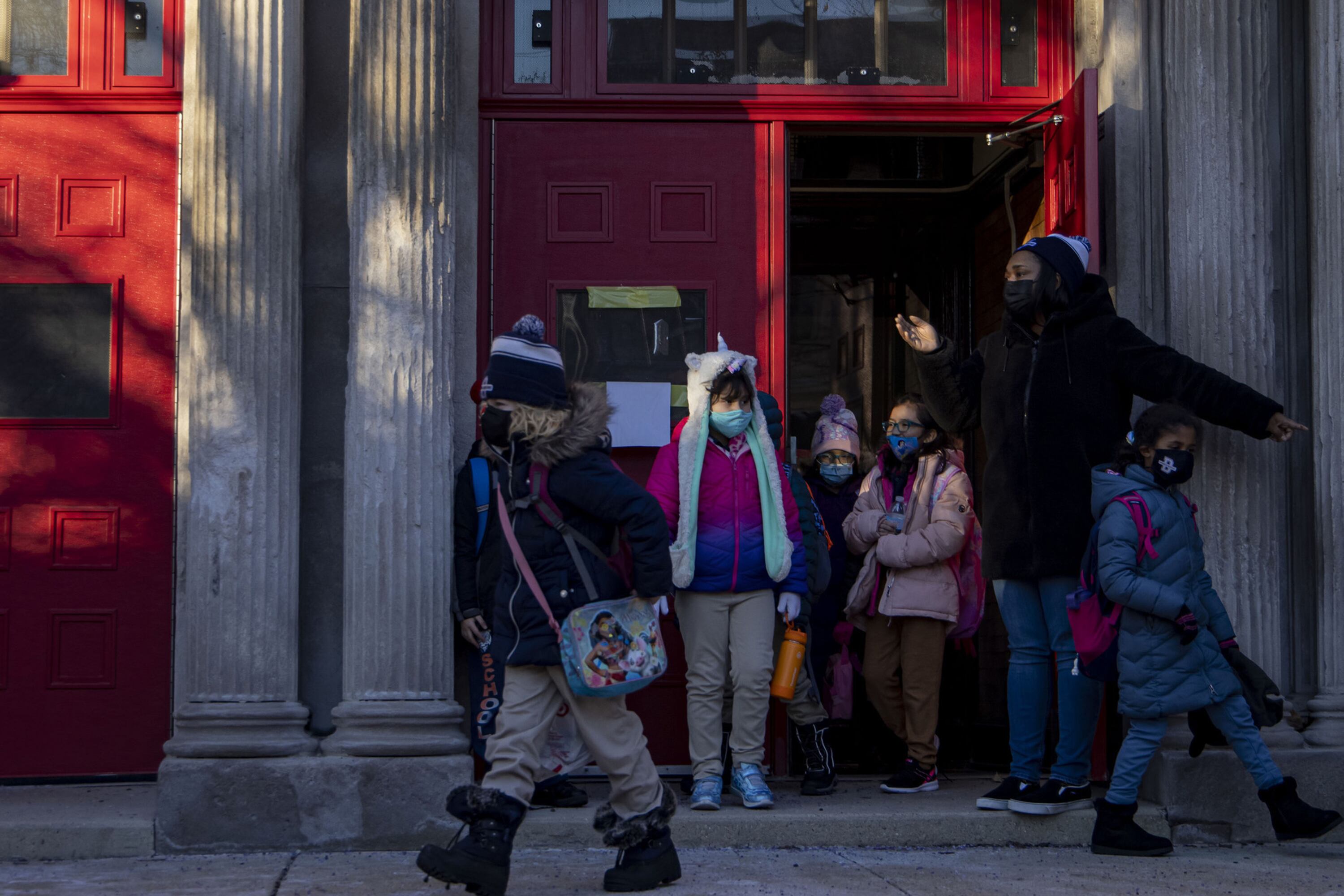 Children are bundled up in winter coats as they leave a Chicago school building in January.