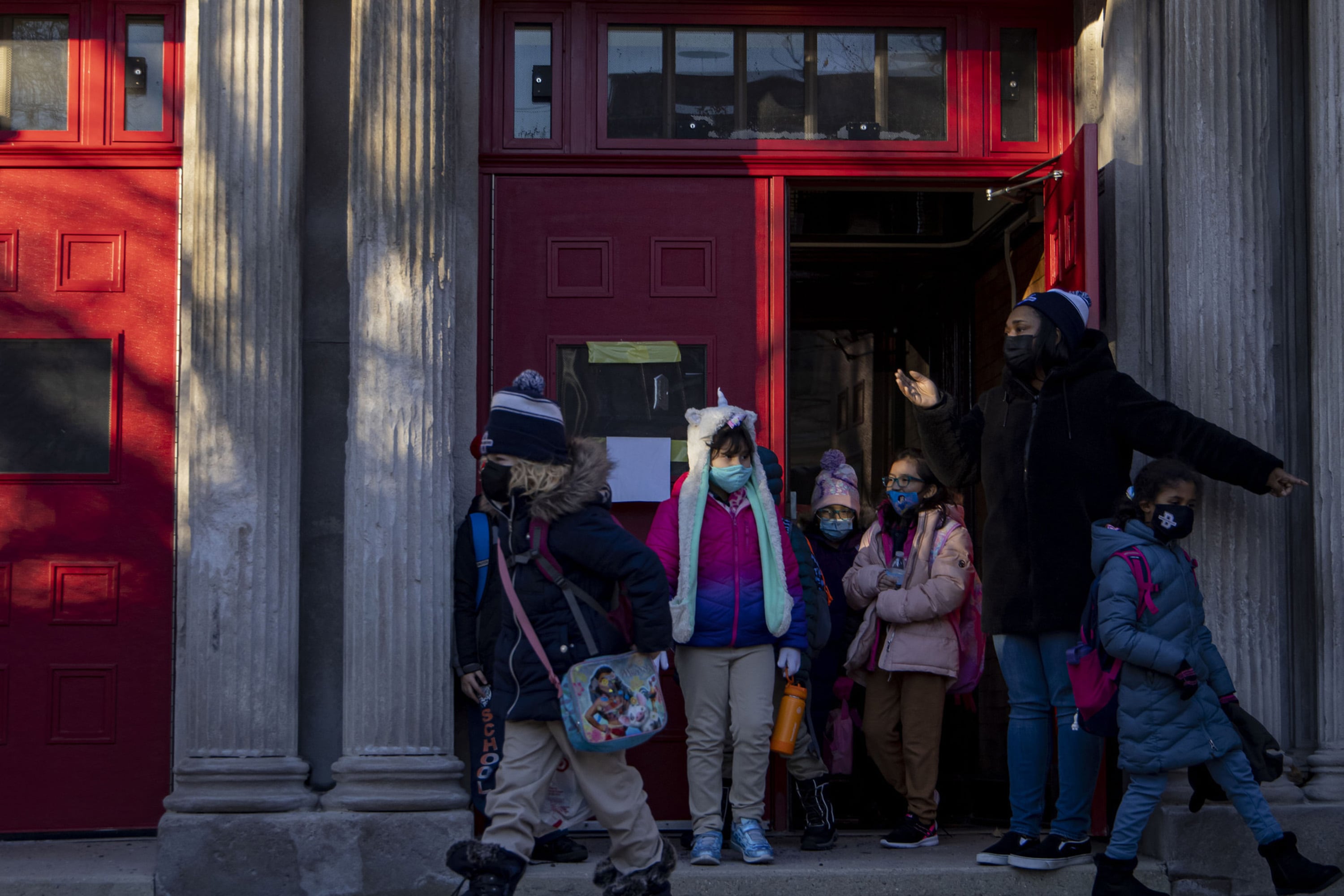 Children are bundled up in winter coats as they leave a Chicago school building in January.