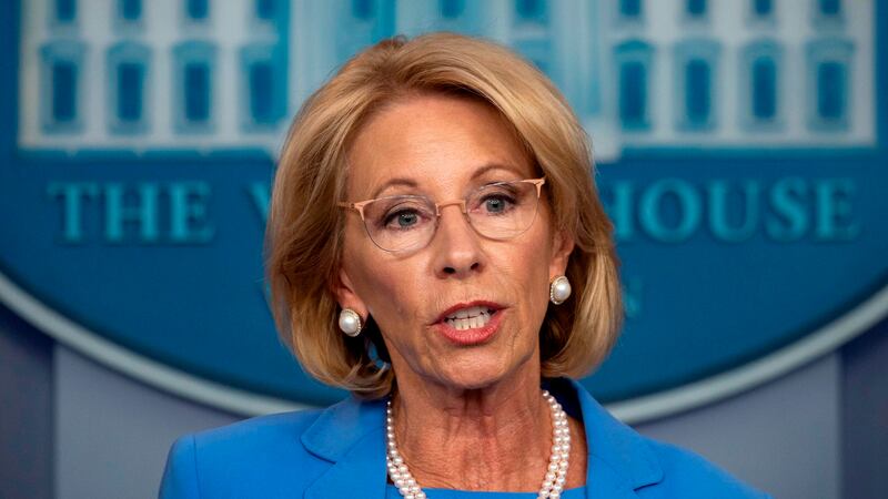 Photo of Betsy DeVos in pearls and blue shirt