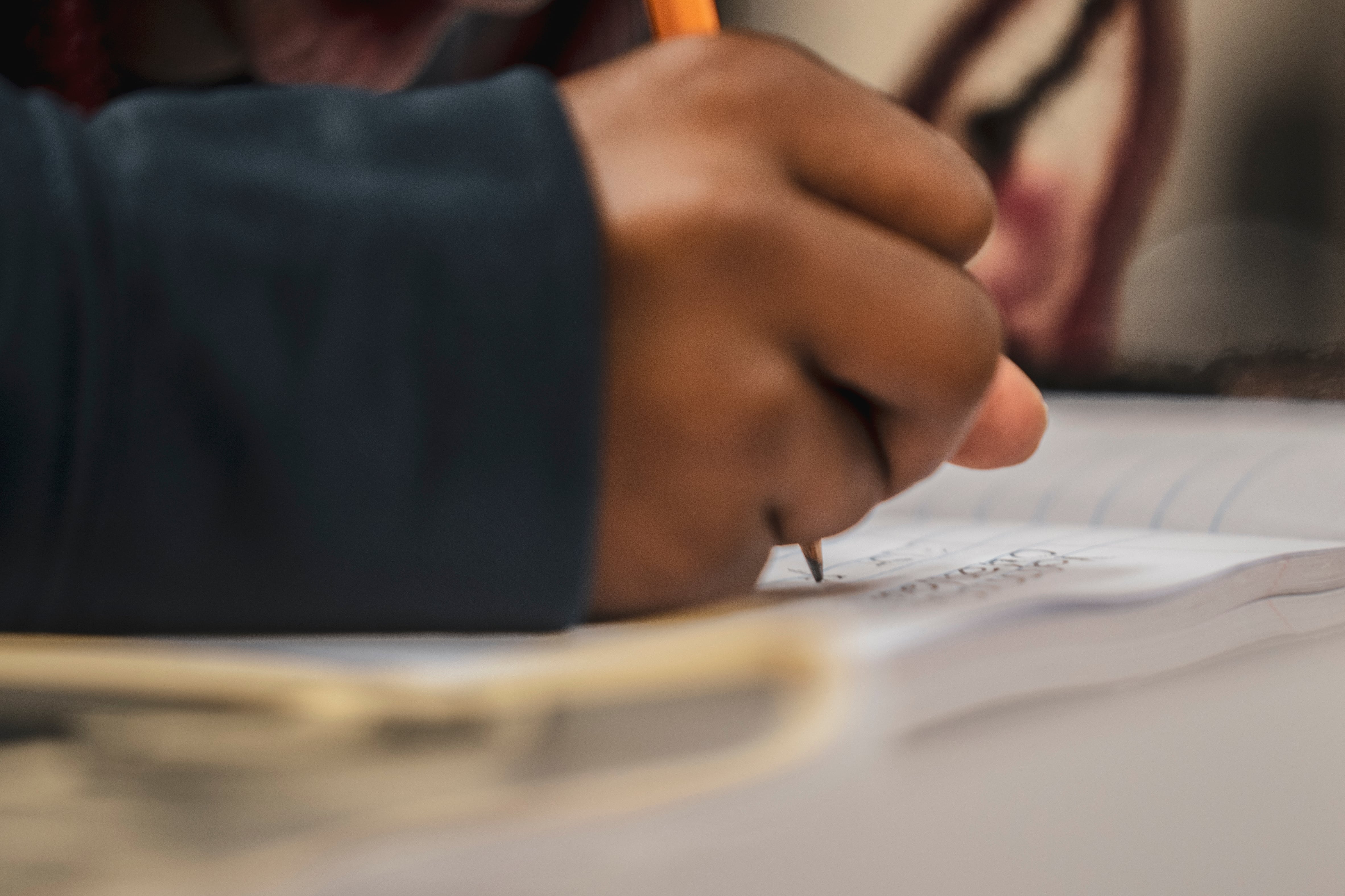 A close up of a hand writing on white paper.
