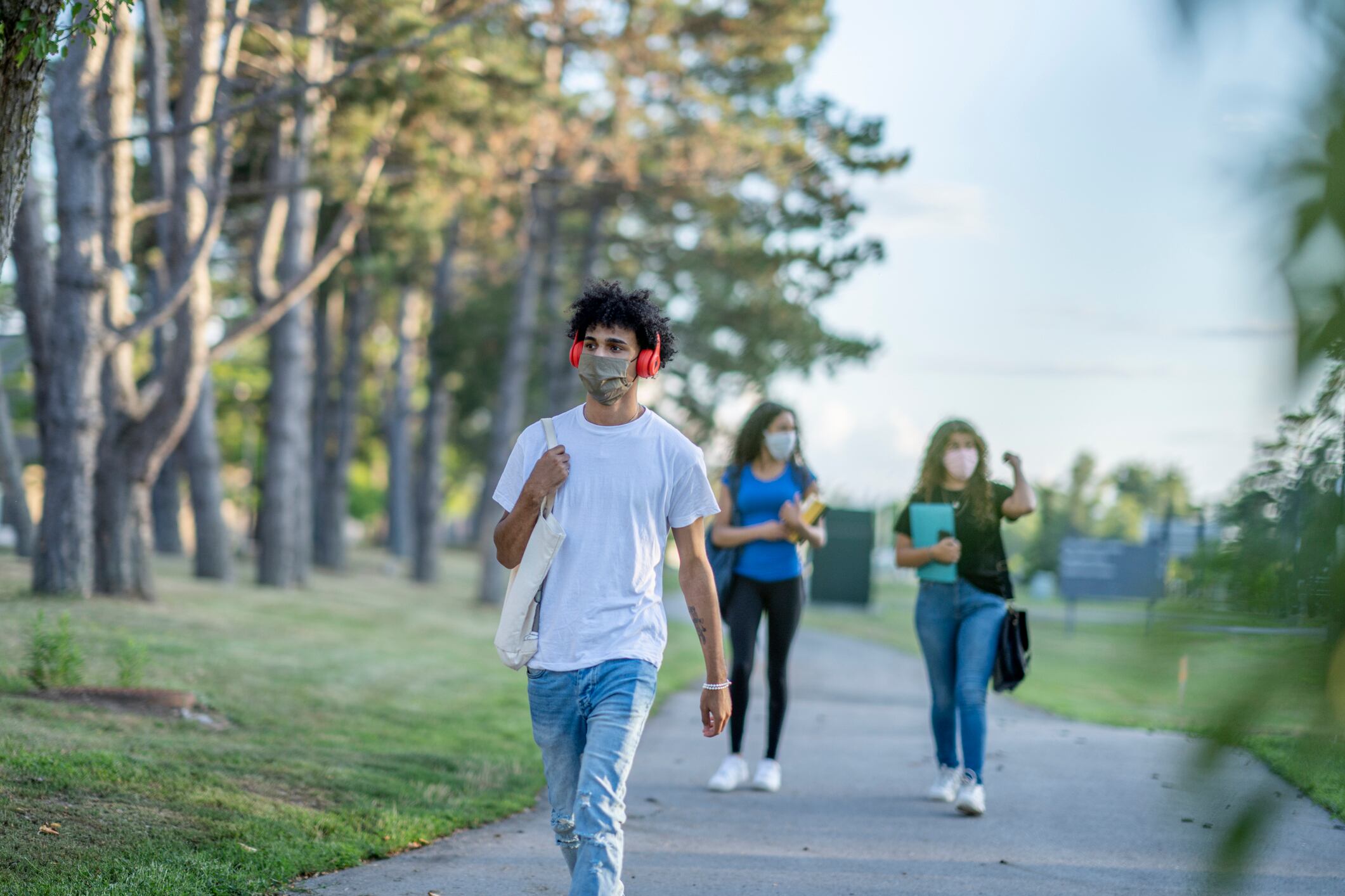 Group of students wearing reusable face masks while walking together on campus.