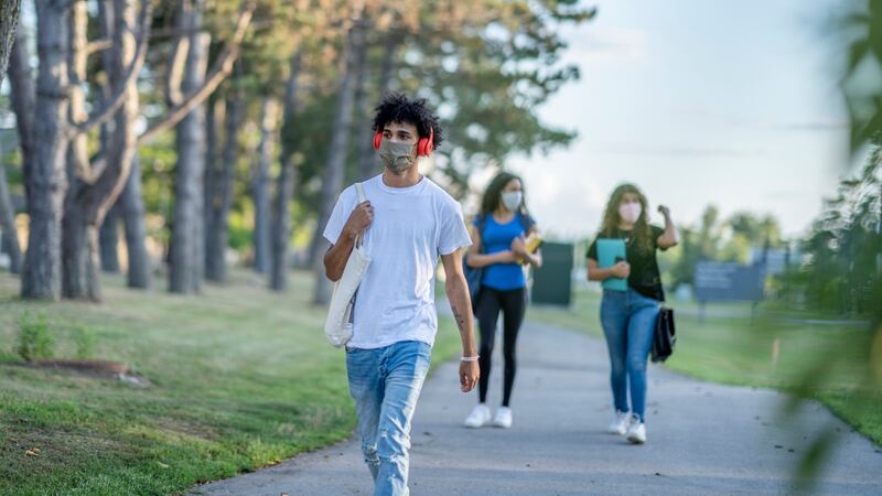 Group of students wearing reusable face masks while walking together on campus.
