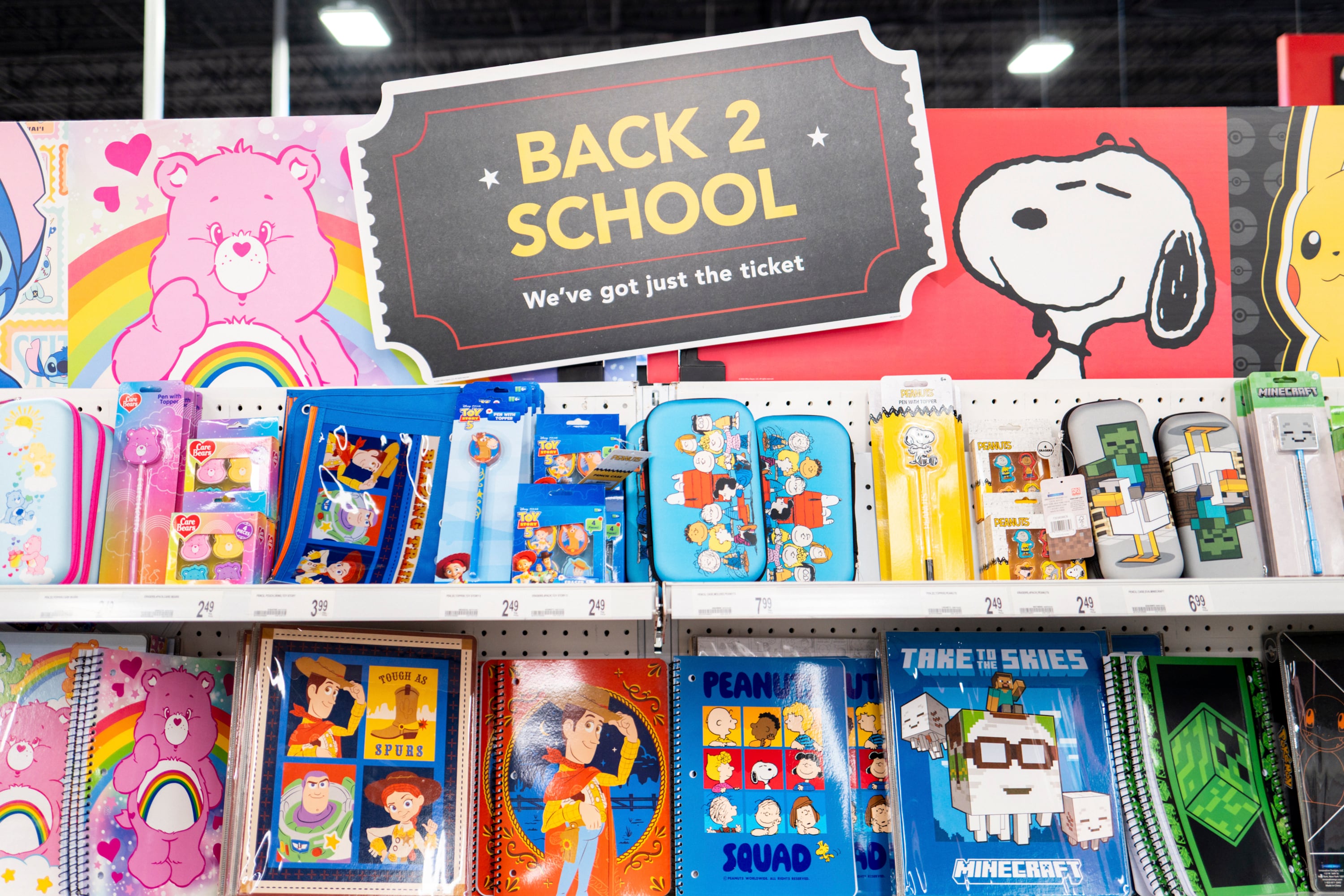 A lot of school supplies, like notebooks and pen cases, are on a shelf.