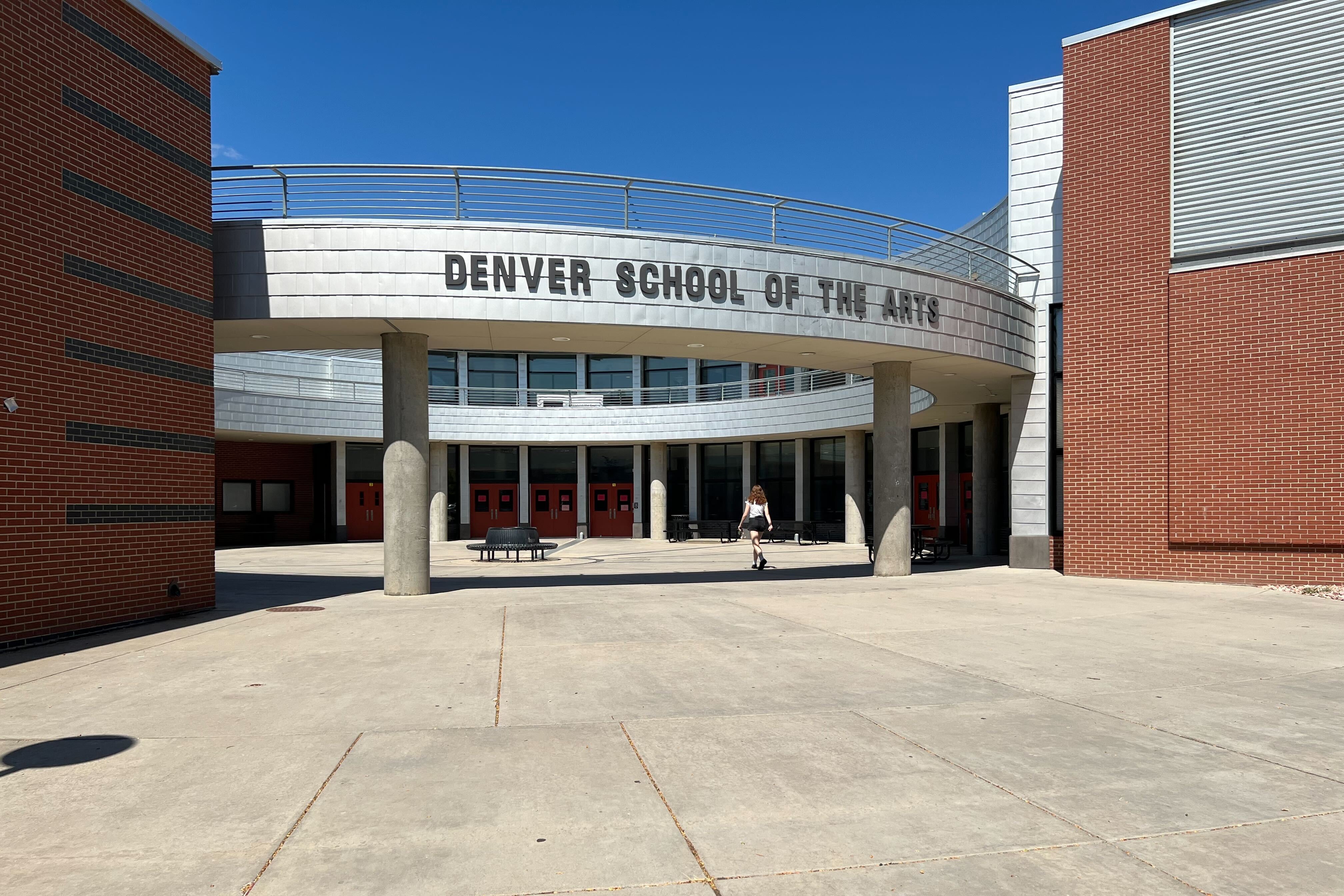 A student walks in the front doors of Denver School of the Arts.