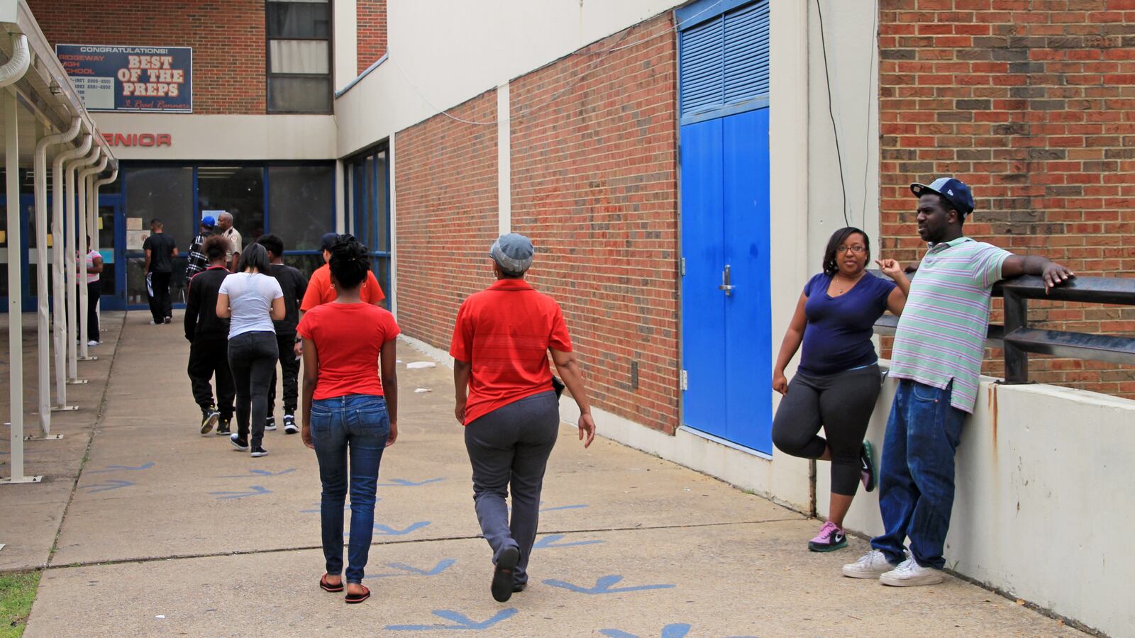 Allen Thornton and his daughter, Sharonda, wait Wednesday outside of Ridgeway High School, where long lines of parents form for summer school registration.