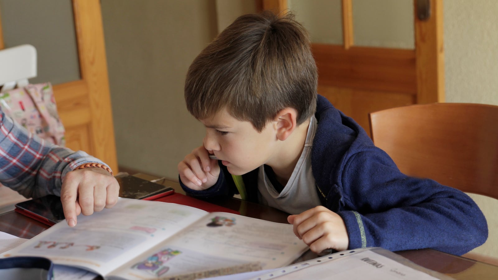 A boy doing school work at a desk.