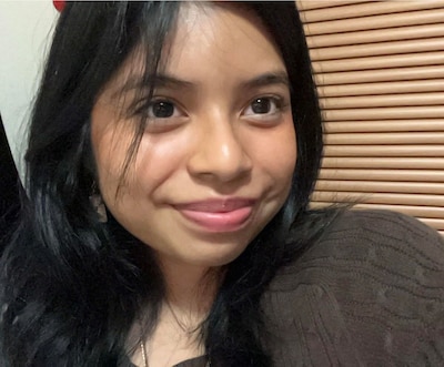 Headshot of a teenage girl with dark hair, wearing a dark shirt.