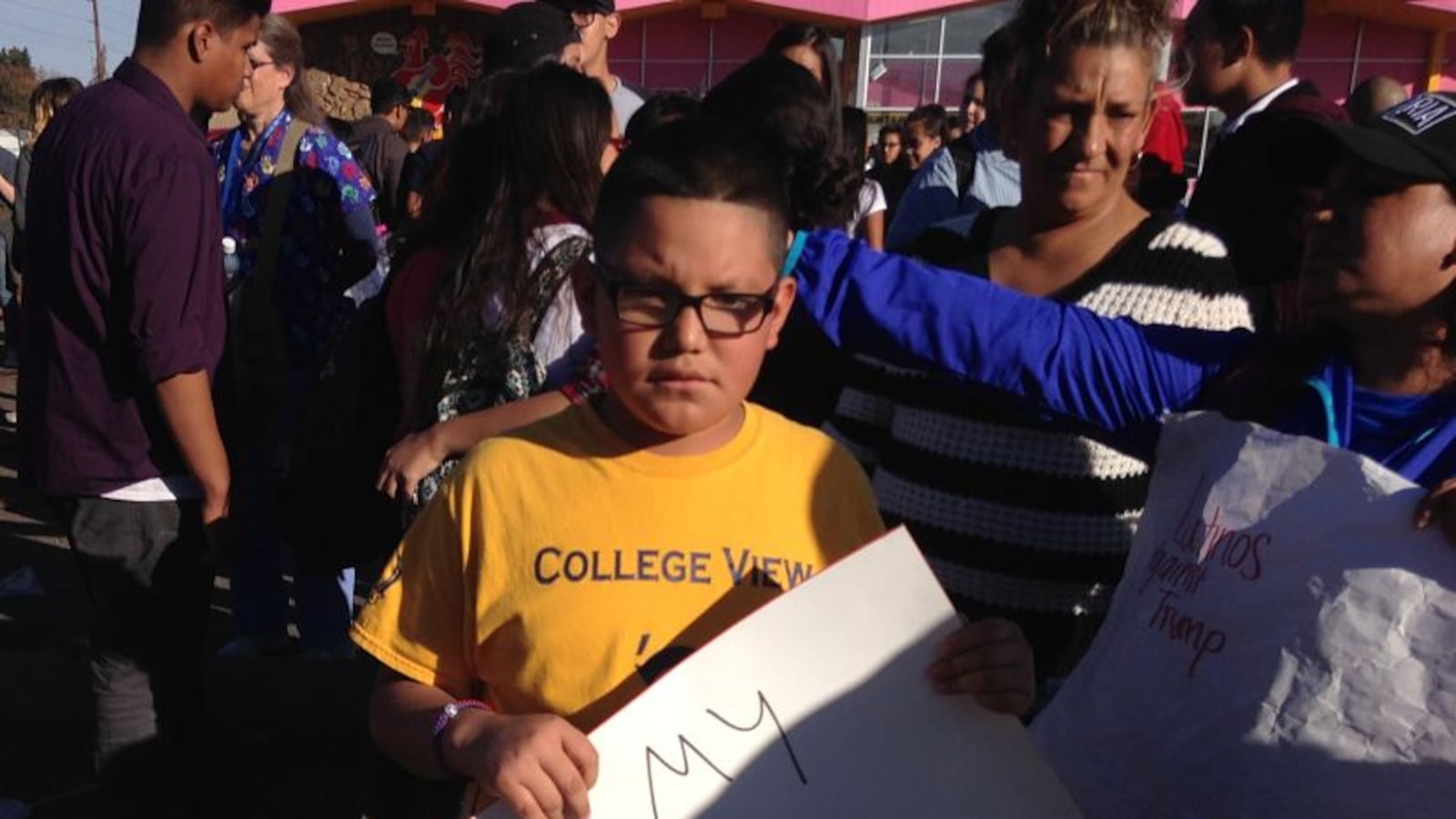 A Denver student holds a sign at a walkout to protest Trump.