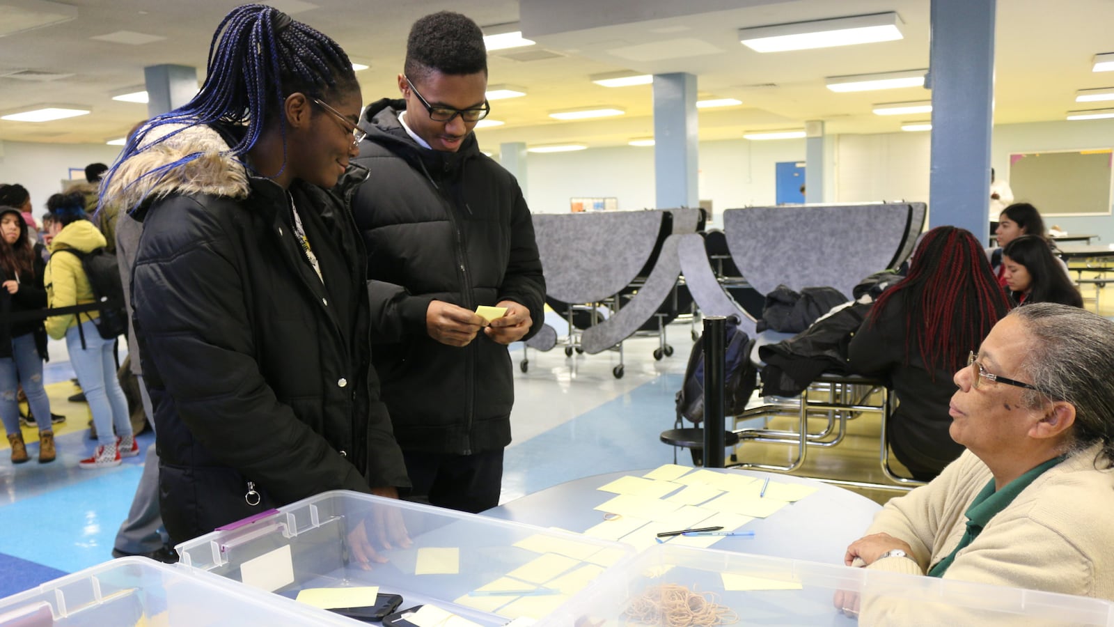 Abigail Thompson, left, and Talike Bennett turn their phones in to Eva Hunte at the Brooklyn Academy of Science and the Environment