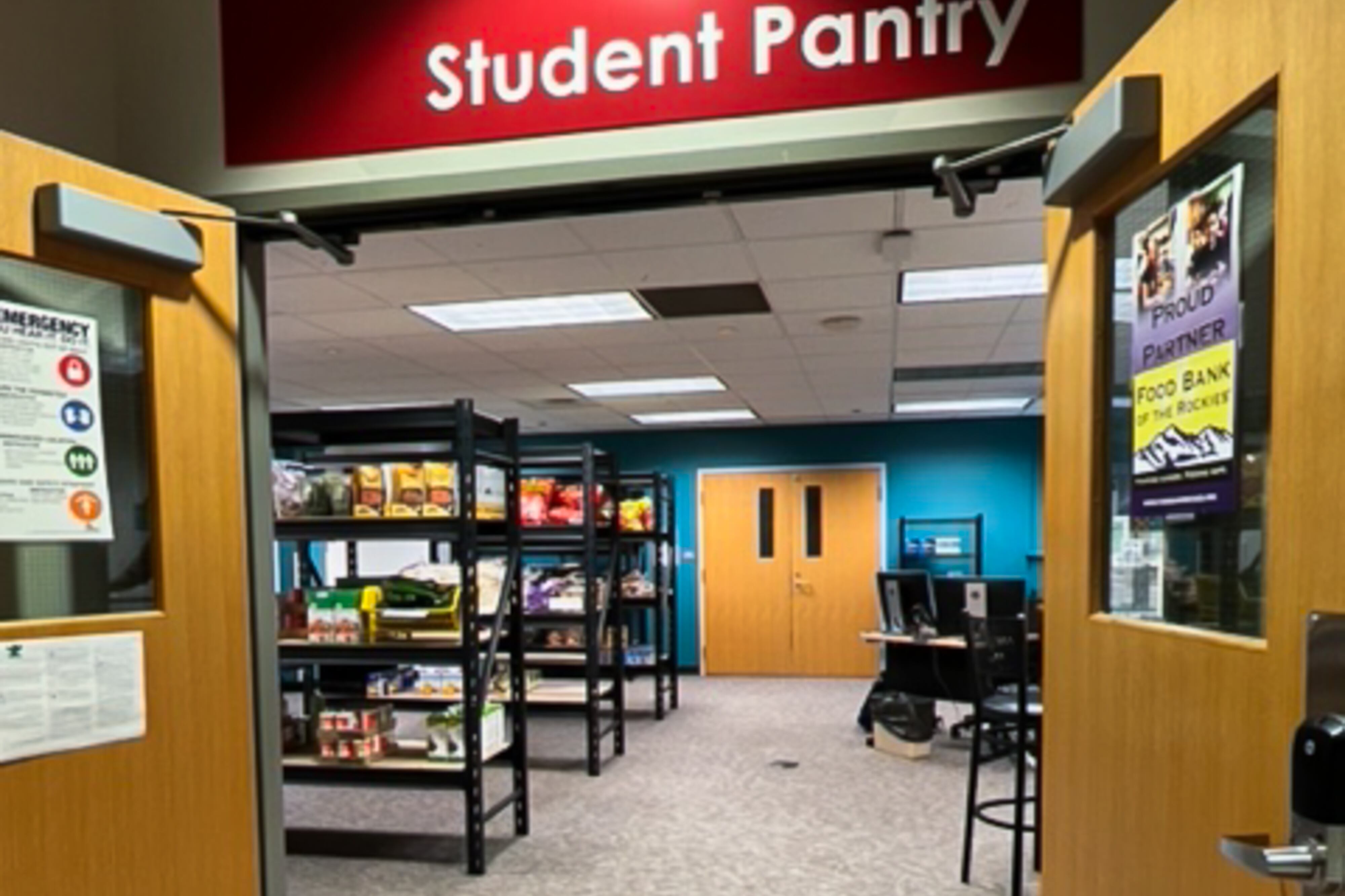 Two brown double doors open wide in a room that has black shelving stocked with food.