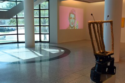 Giant windows on the left of the image with a gallery wall on the right side.